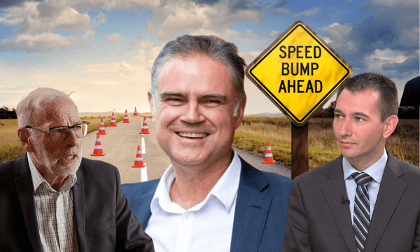 Three men in suits appear in the foreground of a rural road lined with traffic cones and a yellow "Speed Bump Ahead" sign under a cloudy sky. The man in the center is smiling, while the others appear serious.