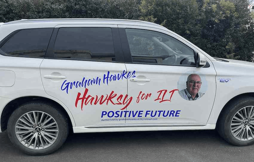 A white car emblazoned with the slogan Hawksy for ILT