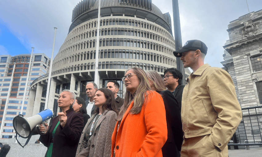 The Green Party, including Marama Davidson, Chloe Swarbrick, Lan Pham, Scott Willis, Huuhanna Lyndon, Francisco Hernandez and Benjamin Doyle, stand in front of the Beehive.