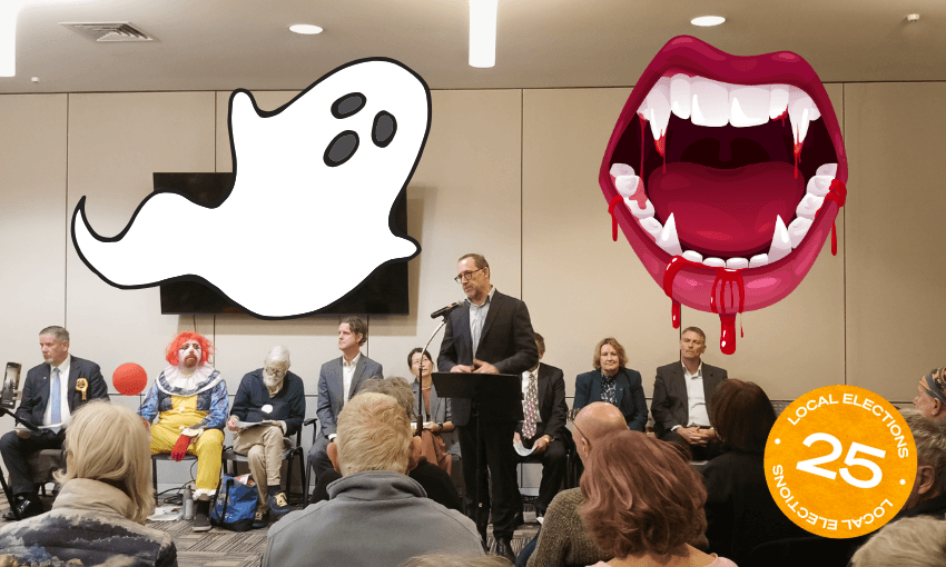 A man speaks at a podium in a crowded meeting room. Seated behind him are people, including someone dressed as a clown. Large cartoon ghost and vampire mouth graphics are added, along with a “Local Elections 25” sticker.