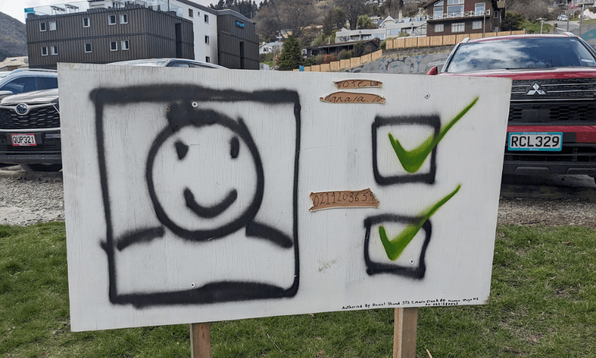 a spray painted smiley face with two boxes and green ticks