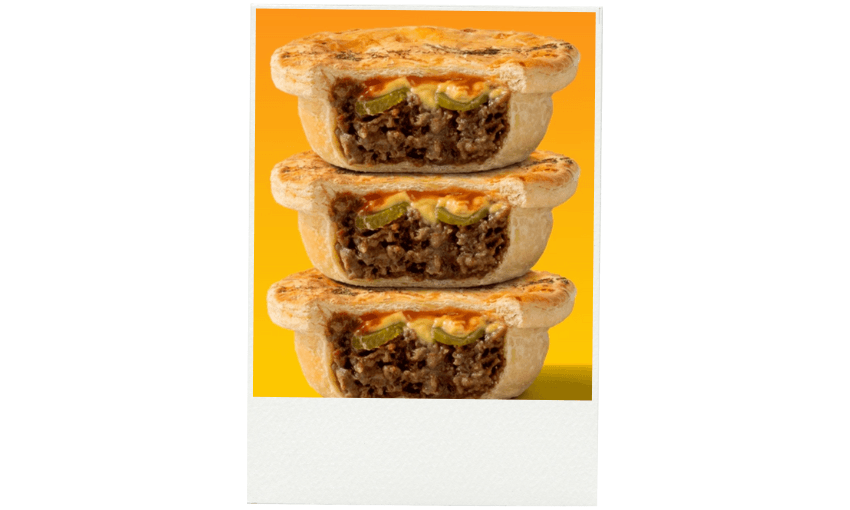 Three beef pies are stacked on top of each other, each cut in half to show the filling of minced beef, cheese, and pickle inside. The background is a gradient of yellow and orange.