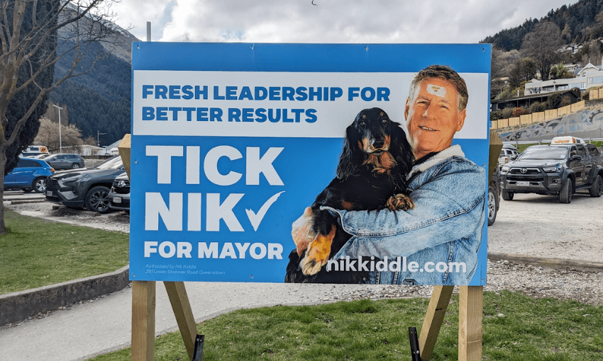 Election sign for a white man holding a spaniel of some kind and a sign saying 'tick nik"