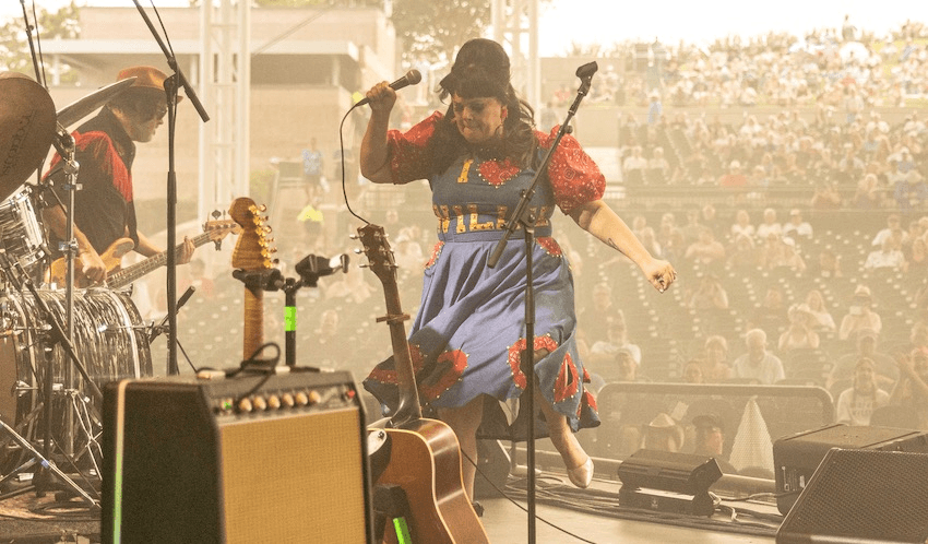 Tami Neilson onstage in front of a large crowd wearing an "I HEART WILLIE" denim dress