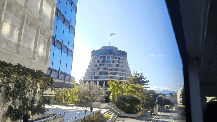 New Zealand's Beehive building on a sunny day with the flag flying. 