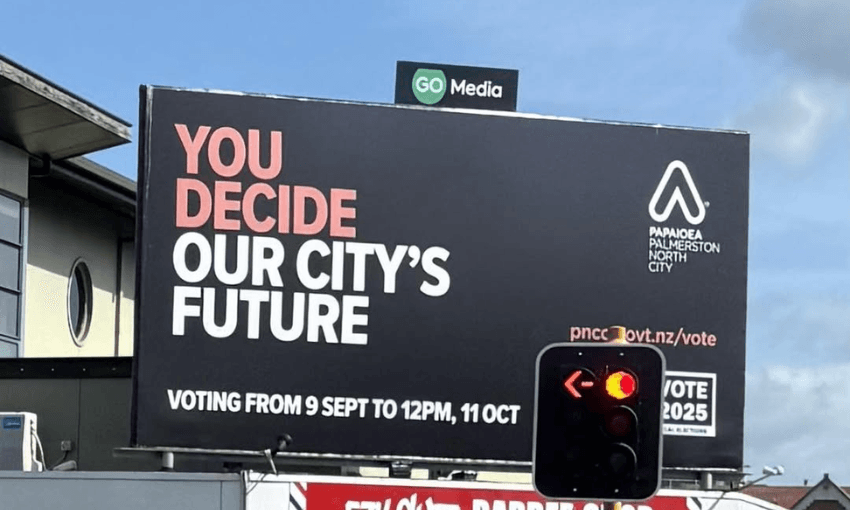 a traffic light partially obscures a sign reading "You decide our city's future"