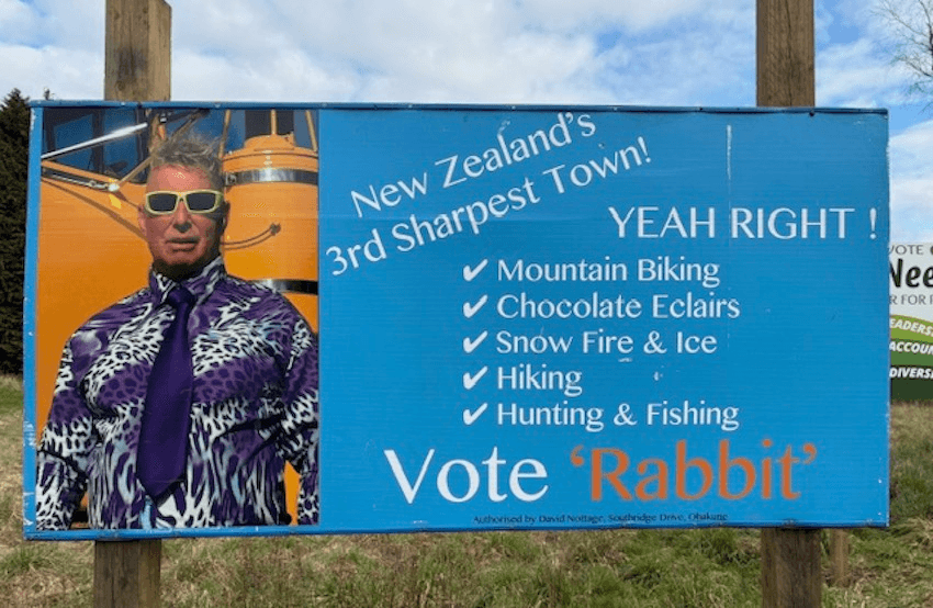 A blue electoral hoarding featuring a man named Rabbit – text reads New Zealand's sharpest town? Yeah Right
