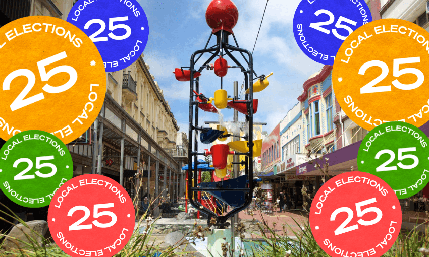 A kinetic sculpture with colorful cups stands on a pedestrian street, surrounded by large circular "Local Elections 25" stickers in red, orange, blue, green, and yellow.