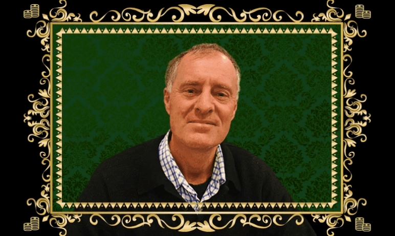 a white man in a collared shirt and sweater with a black and green background and gold frame around him