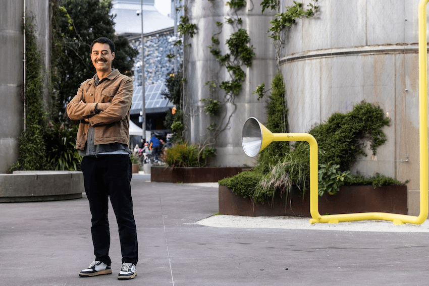 Tāmati Rimene-Sproat stands with his arms folded and smiles at the camera