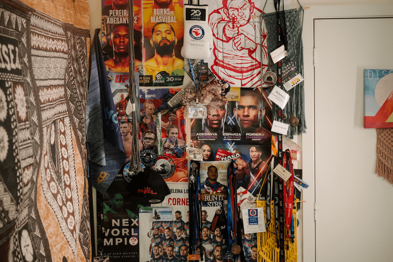 A wall is covered in event passes and posters for UFC fights