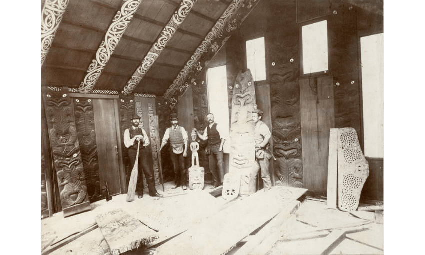 A black and white photo showing the inside of Hau Te Ananui o Tangaoa. Four men are standing with tools. 