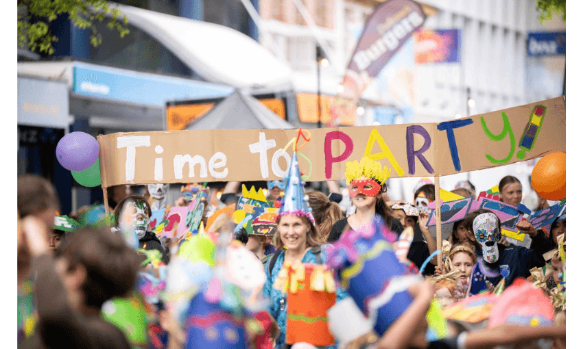 A photo of a street party where someone has made a sign on cardboard that says ' Time to Party'.