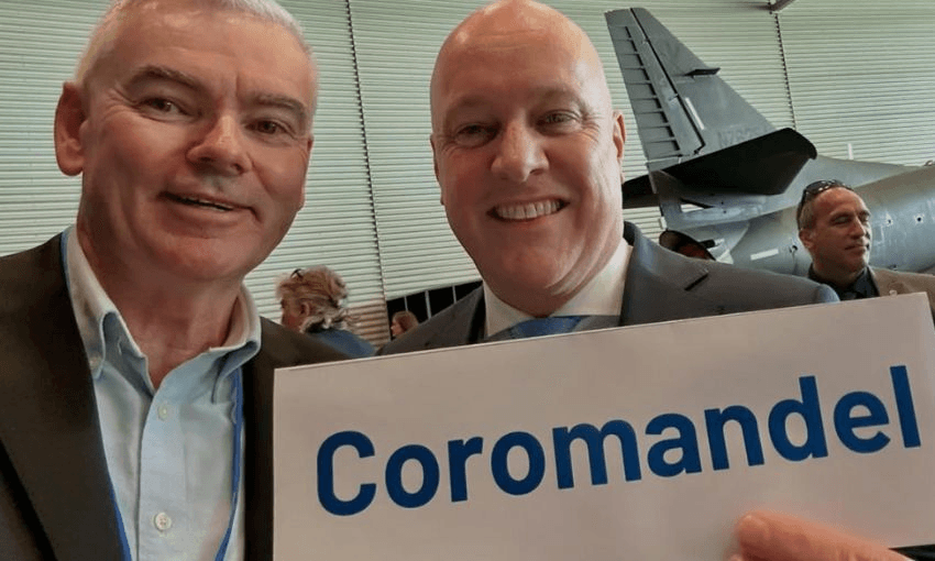 Scott Simpson smiles beside prime minister Christopher Luxon, who is holding a sign reading "Coromandel".