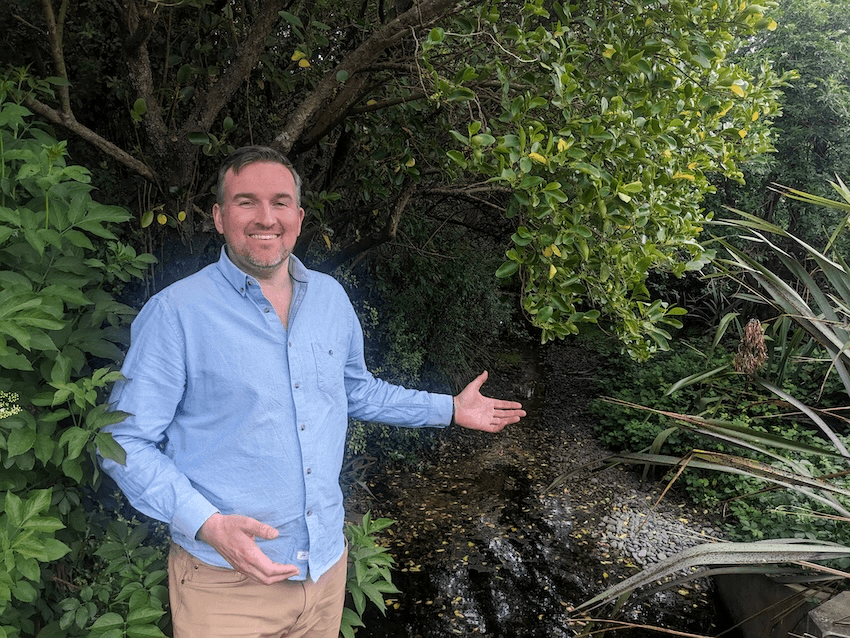 a white man in a blue shirt with the river behidn him