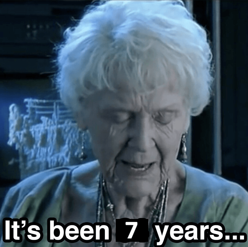 An elderly woman with white hair looks down sadly, with the text “It’s been 7 years…” in bold letters at the bottom of the image.