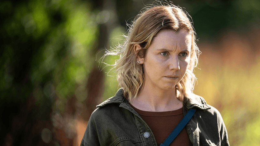 An angry woman with messy hair looks into the distance