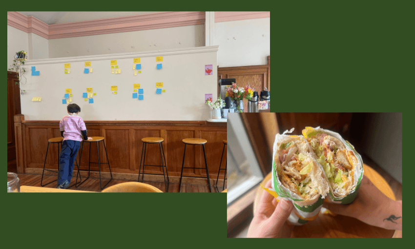 A child stands at a counter covered in sticky notes on a wall in a cozy cafe; next to it, a close-up of a hand holding a halved, loaded wrap sandwich.