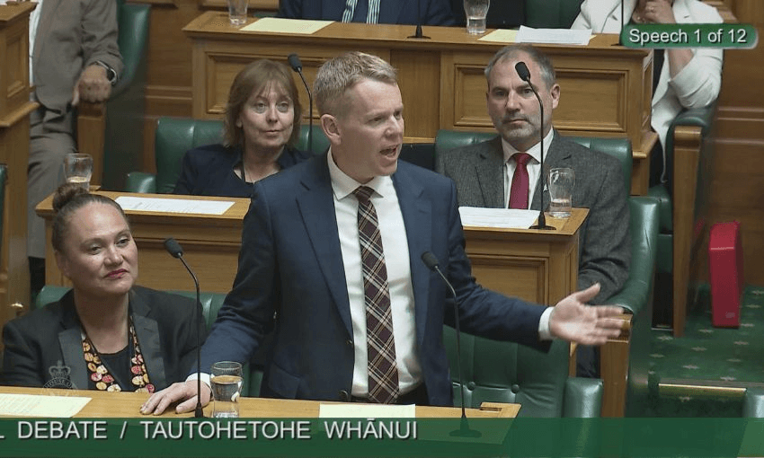 Chris Hipkins, wearing a suit and plaid tie, speaks in the House.