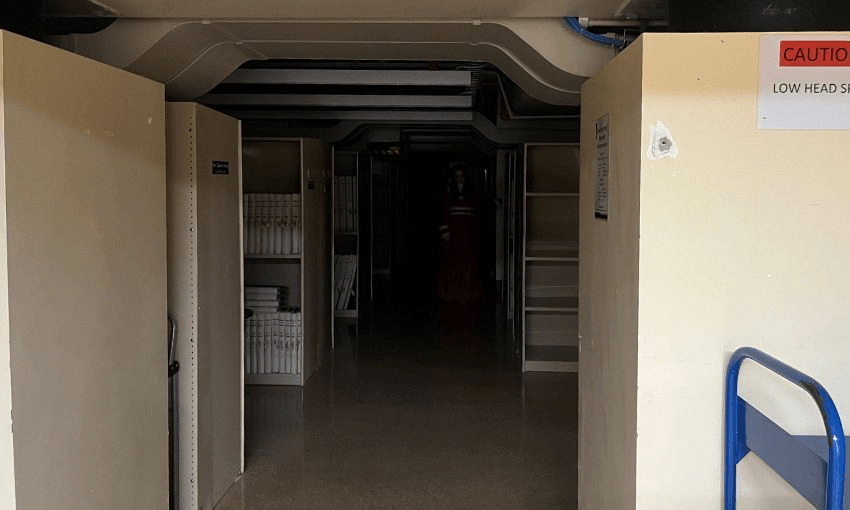 Inside parliament's archives, where a woman in a red gown can be seen standing in the dark distance.