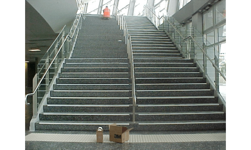 stairs where some have qhite tape and are easy to see and some don't and are hard to make out