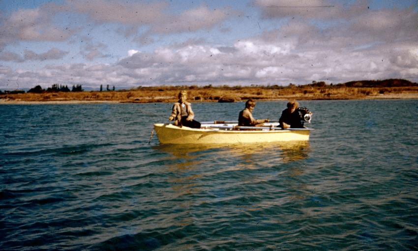 A yellow boat holding three people sits in the middle of Opihi Bay.