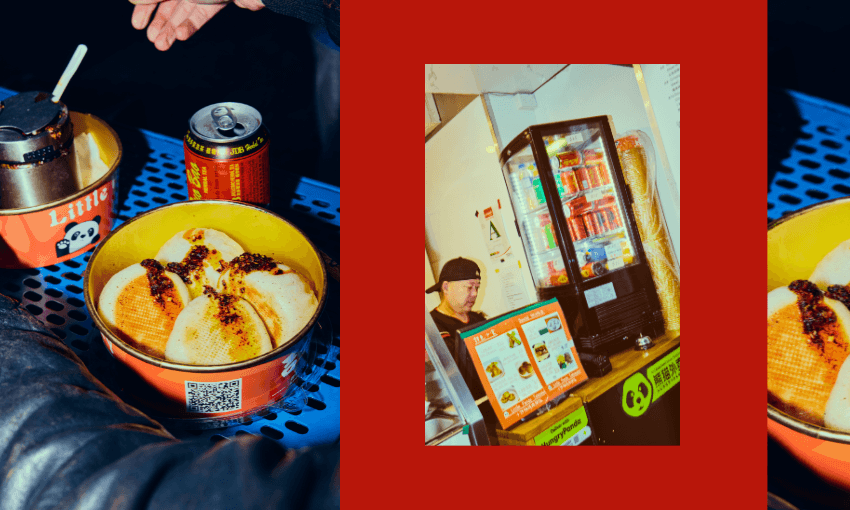 A bowl of sliced dumplings topped with chili oil sits on a blue table next to a drink and sauce container. To the right, a man stands behind a counter with a refrigerator and menu at a food stall.