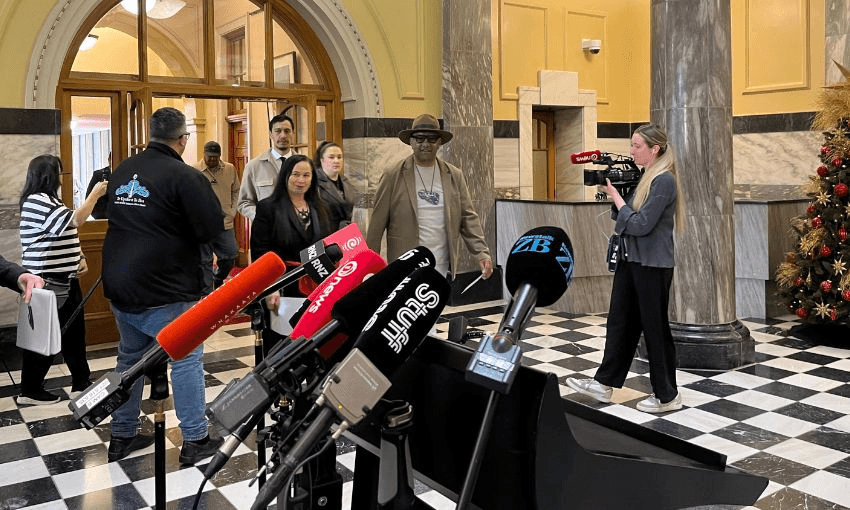 Te Paati Maaori Debbie Ngarewa-Packer and Rawiri Waititi enter through a door onto parliament's tiles, where a microphone stand is waiting.