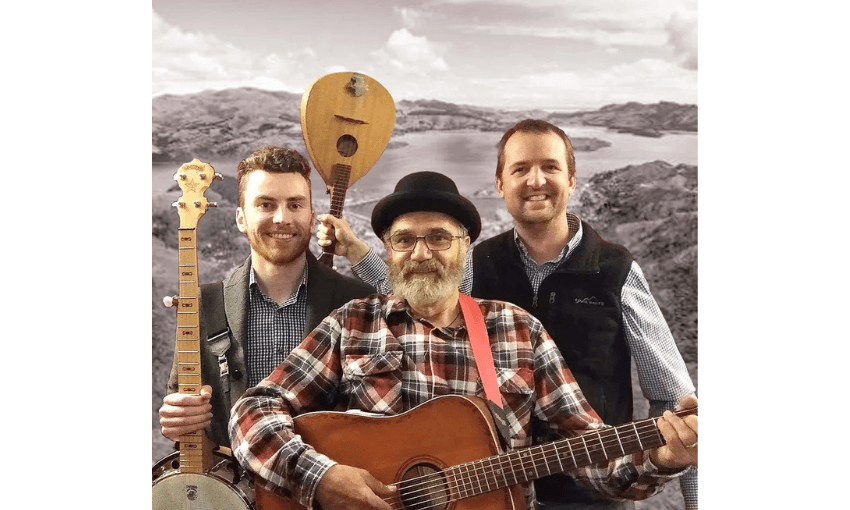 A photo of a three piece band with a guitar and banjo visible. 