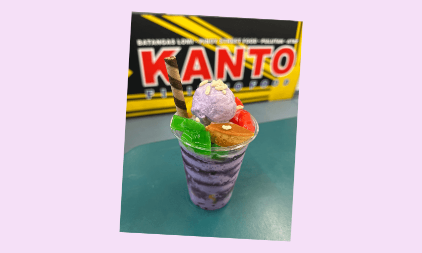 A cup of ice dessert with colourful fruit toppings in front of a Kanto sign