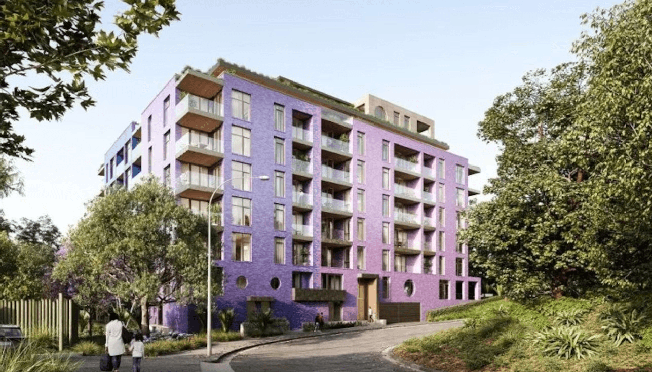 A modern, nine-story apartment building with purple exterior walls, large windows, and balconies, surrounded by trees and greenery. Two people walk on the curved path in the foreground.