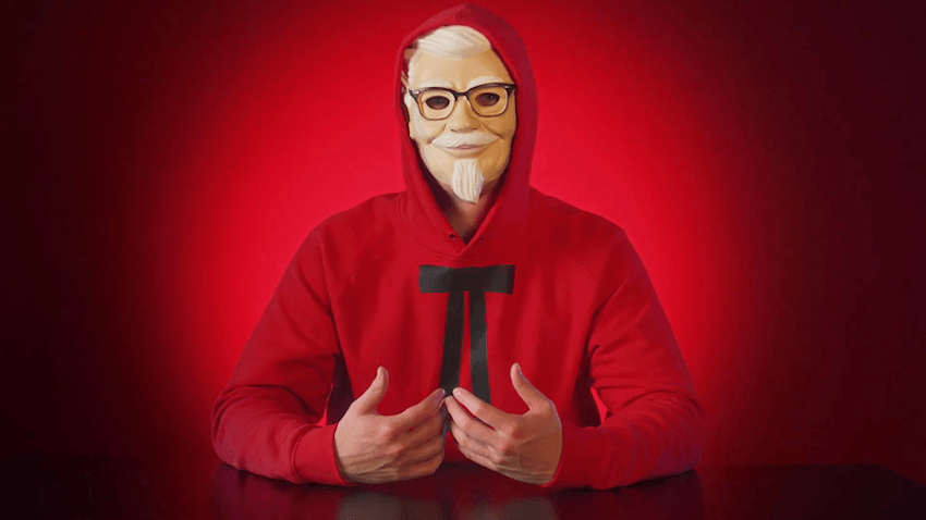 A man in a KFC colono mask in front of a red background