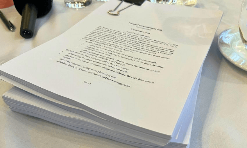 Stacks of hundreds of pieces of paper sit on a table.