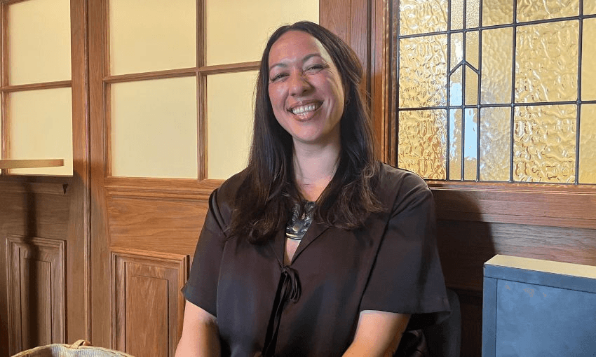 Kahurangi Carter grins while sitting at a pub booth.