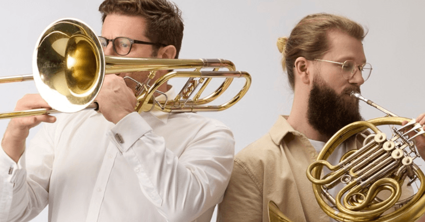 Two man playing brass instruments. 