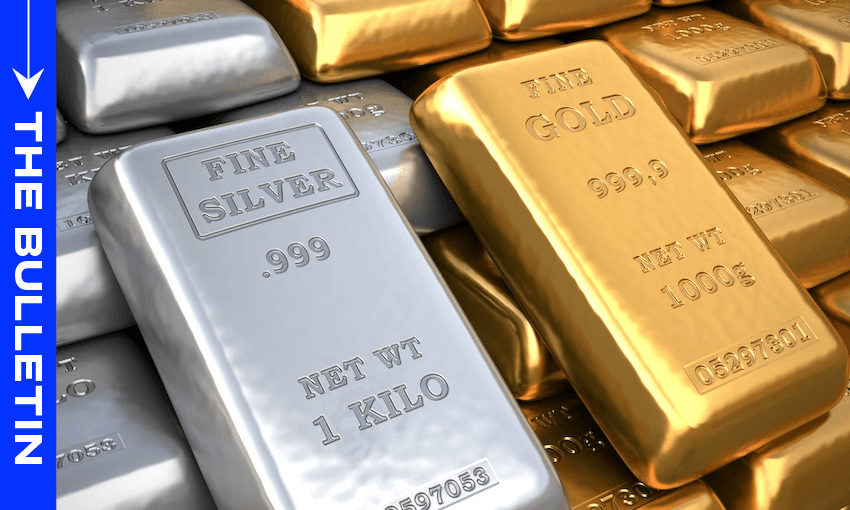 Stacks of silver and gold bars labeled “FINE SILVER” and “FINE GOLD,” with weights and purity markings, are shown closely arranged. A blue vertical banner on the left displays “THE BULLETIN” in white text.