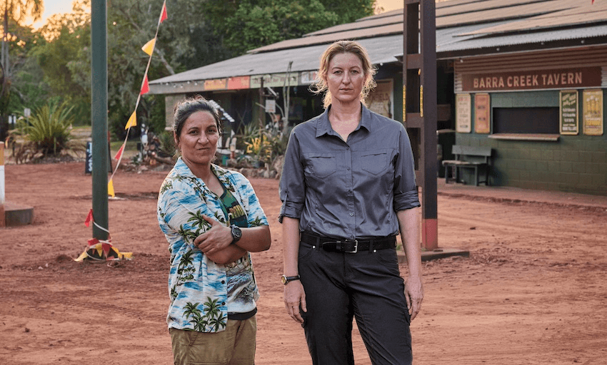 Dulcie and Eddie in a scene from Deadloch, standing in front of a dusty Australian pub