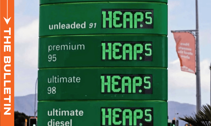 A green petrol station price sign displays fuel types—unleaded 91, premium 95, ultimate 98, and ultimate diesel—with the cost for each listed as “HEAPS.” An orange “The Bulletin” banner is on the left.
