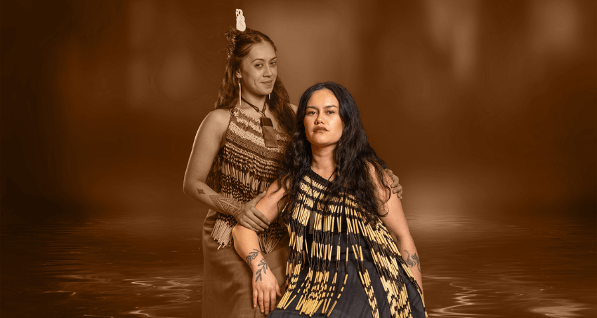 A production image of two wāhine Māori: one is seated and the other is standing at her shoulder, to indicate she is the tupuna.