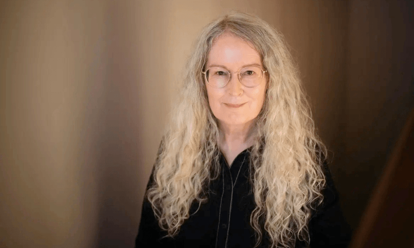 A photo of Elizabeth Knox who has long grey wavy hair and is wearing black.