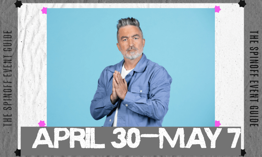 A photo of comedian Dai Henwood wearing a denim shirt with a light blue background behind him. He's looking quizzically at the camera and has his hands in a prayer position.
