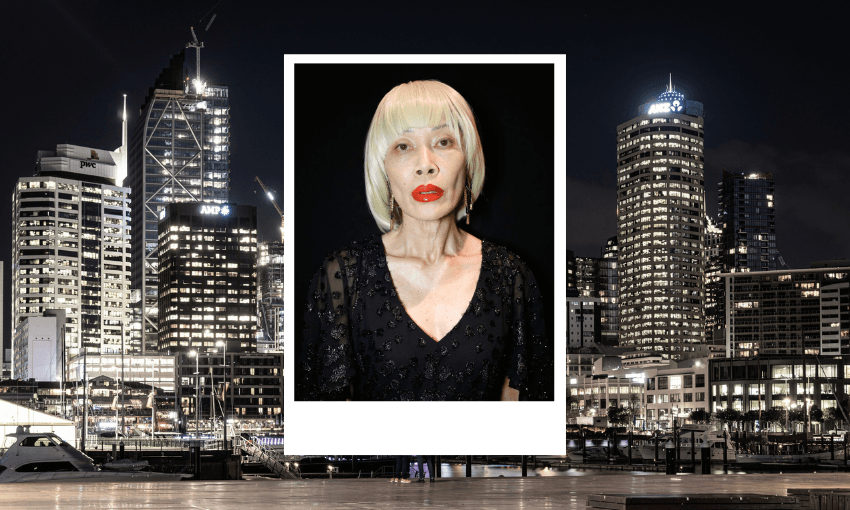 a model portrait of a woman with a bleached blonde bob and striking red lipstick. in the background a cityscape of downtown Auckland at night