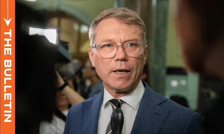 a man with clear rimmed glasses and short hair talks to media