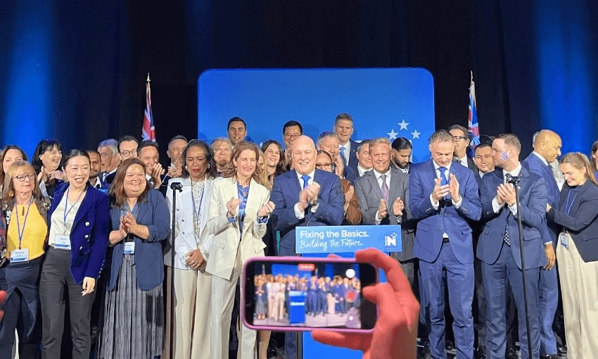 a large group of politicians wearing suits and blouses stand on a stage for a group photo