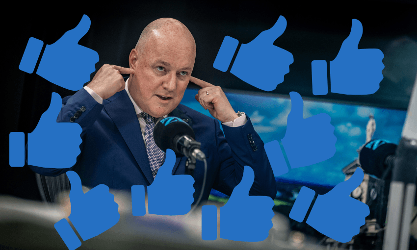 A man in a suit covers his ears with his fingers while surrounded by multiple blue thumbs-up icons, sitting at a desk with microphones and a blurred background.