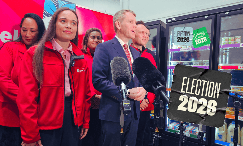 A group of people in red jackets and a man in a suit stand before microphones in a store. “Election 2026” signs are visible on fridge doors and as a graphic overlay.