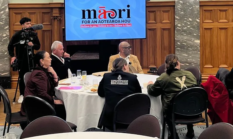 A table under a Te Pāti Māori sign occupied by Rawiri Waititi, Debbie Ngarewa-Packer, John Tamihere and two women.