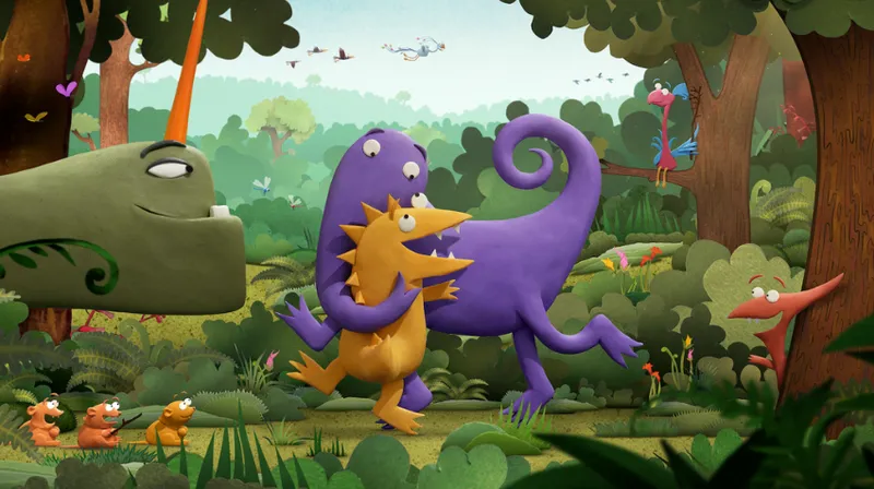 A promotional image from the film Kiri and Lou Go Raaa! A stop motion feature starring a small yellow and small purple dinosaur who are hugging in the frame. There is also a large green dinosaur with a horn, small gerbil like creatures, and another little dinosaur adjacent creature smiling at the hugging pair. They are in a lush forest.