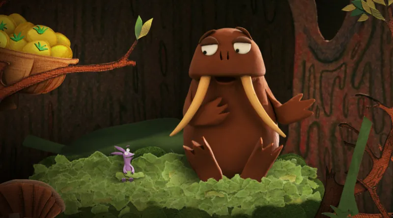 A still from the film Kiri and Lou Go Raaa! Showing the character Small who is like a tiny walrus talking to Pants which is like a tiny leaf character. They're sitting on a pile of torn up leaves that you can see are made of paper.