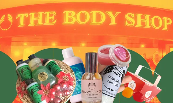 A variety of Body Shop products, including peppermint foot lotion, fuzzy peach perfume and lip balms, are displayed. They are set against a backdrop featuring the illuminated sign of The Body Shop store.